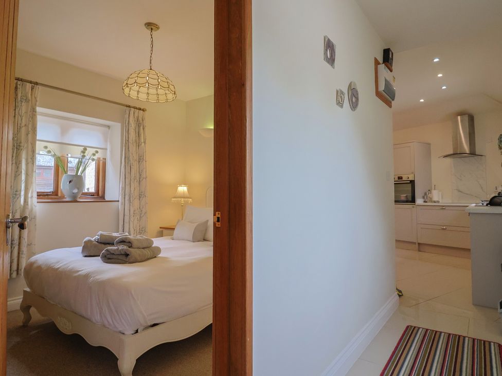 A bedroom with a bed and window view at The Sundowner in Wyke Nr. Axminster