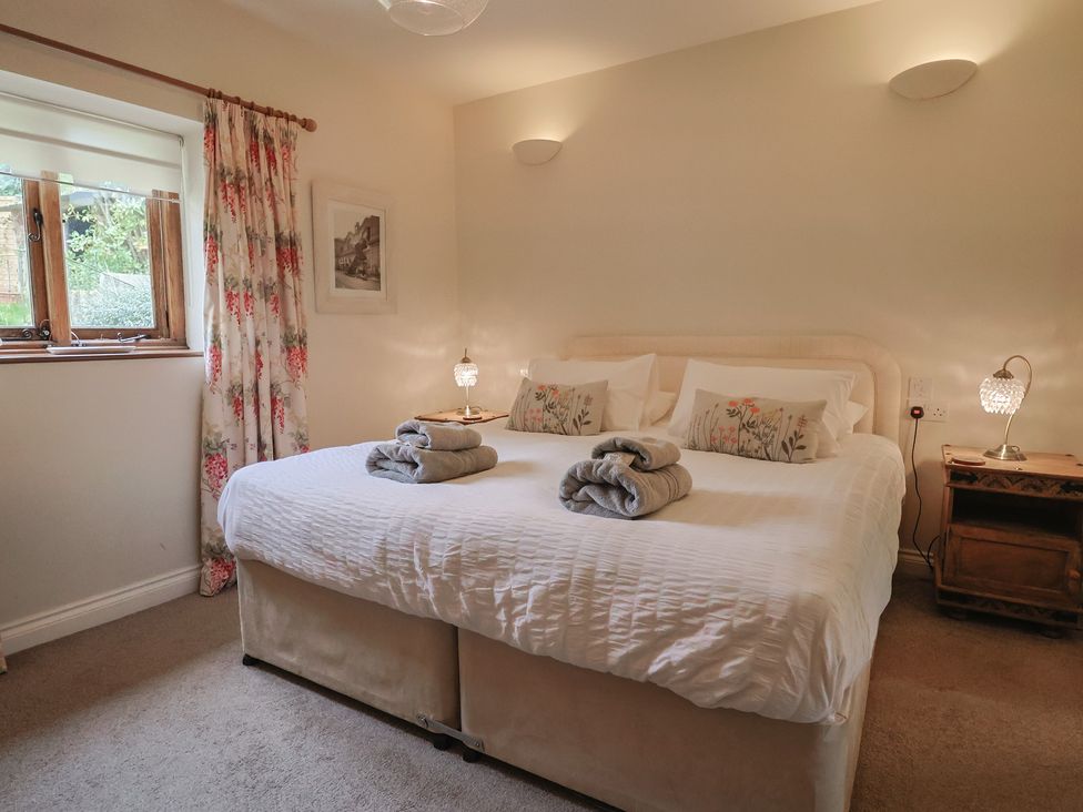A bedroom with a bed and bedside table at The Sundowner in Wyke Nr. Axminster