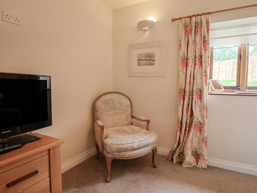 A living room with a chair and a television at The Sundowner in Wyke Nr. Axminster