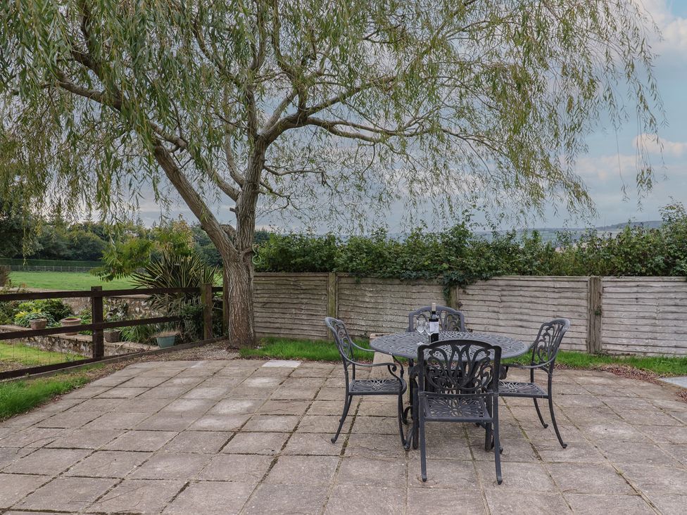 An outdoor patio area with a table and chairs at The Sundowner, Wyke Nr. Axminster