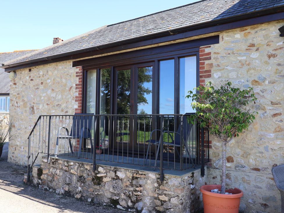 An outdoor area with a railing and chairs at The Sundowner in Wyke Nr. Axminster