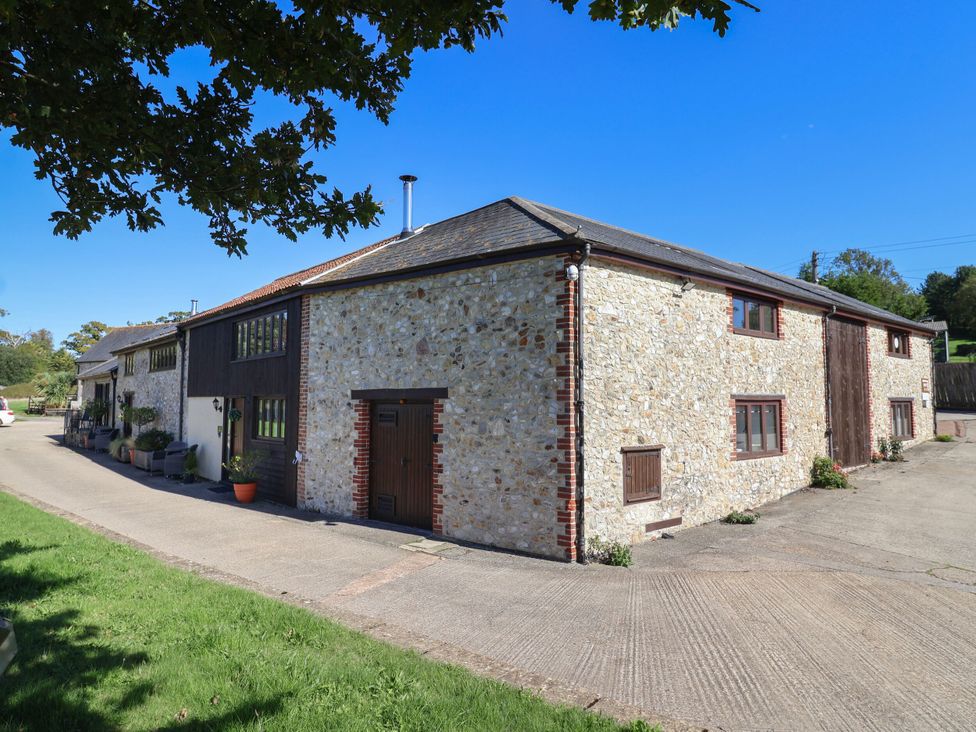 An outdoor view of a stone building with a driveway at The Sundowner in Wyke Nr. Axminster
