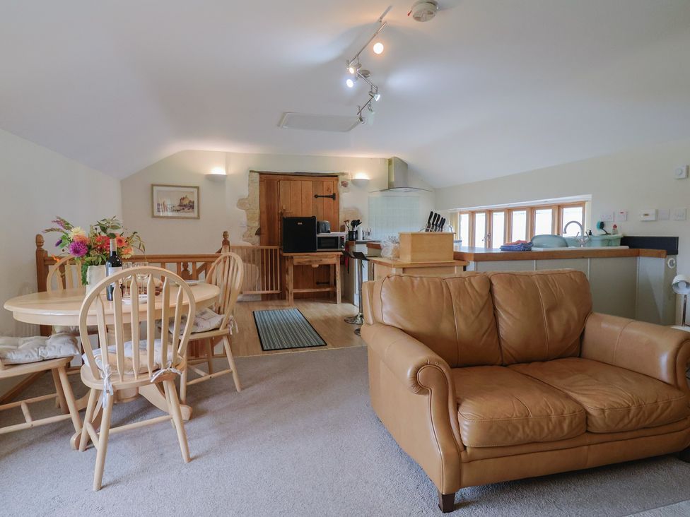 A kitchen with a dining area and couch at The Granary in Wyke Nr Axminster