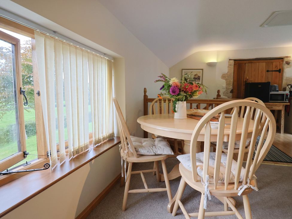 A dining room with a round table and chairs at The Granary in Wyke Nr Axminster