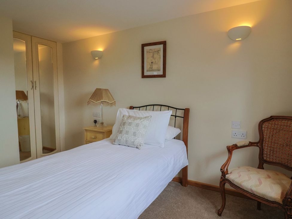 A bedroom with a single bed and a chair at The Granary in Wyke Nr Axminster