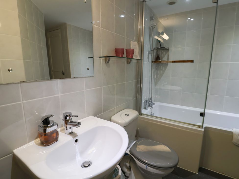 A bathroom with a sink, toilet, and bathtub at The Granary in Wyke Nr Axminster