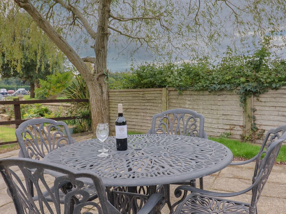 A table with a wine bottle and glass in a garden at The Granary Wyke Nr Axminster