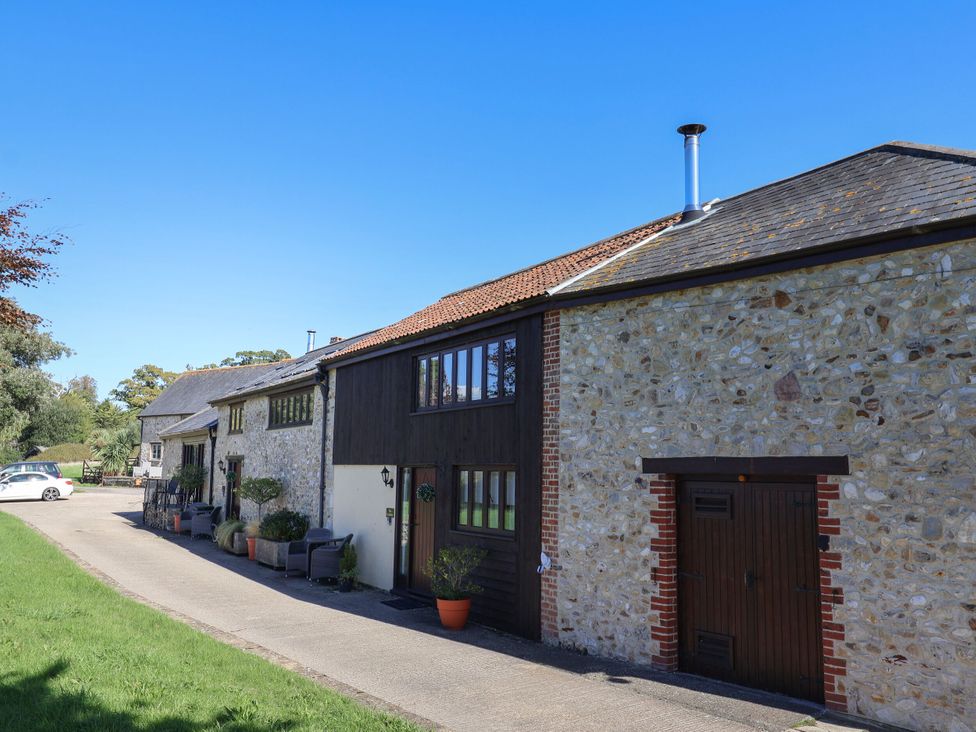 A house with stone walls and a driveway at The Granary in Wyke Nr Axminster