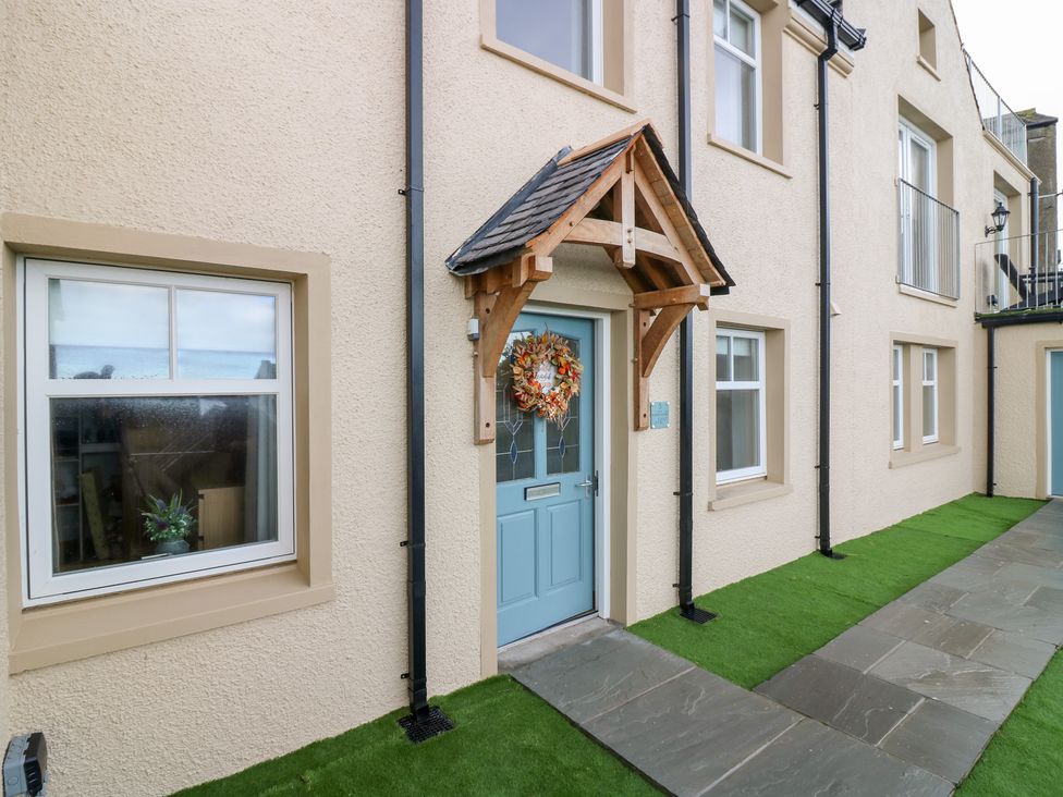 An entrance with a blue front door and stone pathway at The Old Kipper Hoose in Banff
