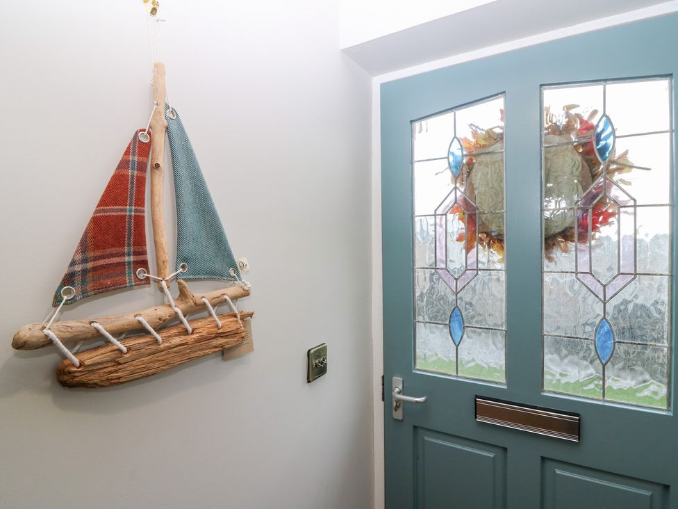 An entrance hall with a sailboat decoration and glass door at The Old Kipper Hoose in Banff