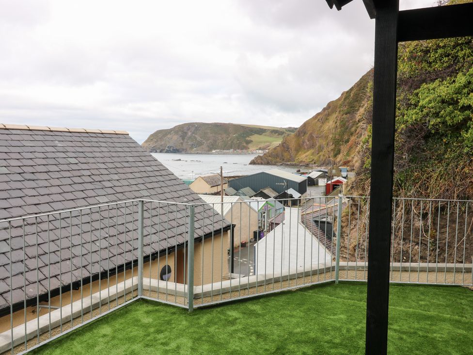 A balcony view of the sea and hills at The Old Kipper Hoose in Banff