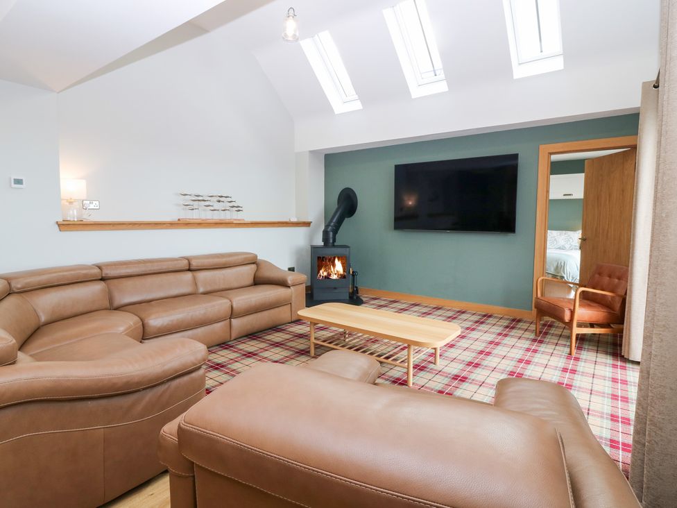 A living room with a sofa and fireplace at The Old Kipper Hoose in Banff