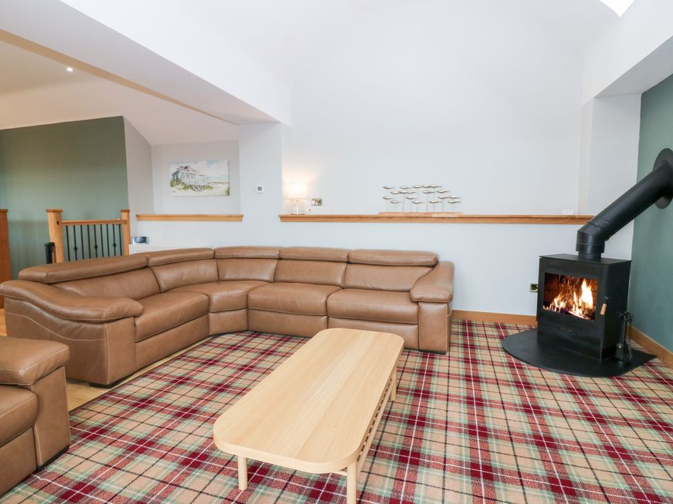 A living room with a sofa and fireplace at The Old Kipper Hoose in Banff