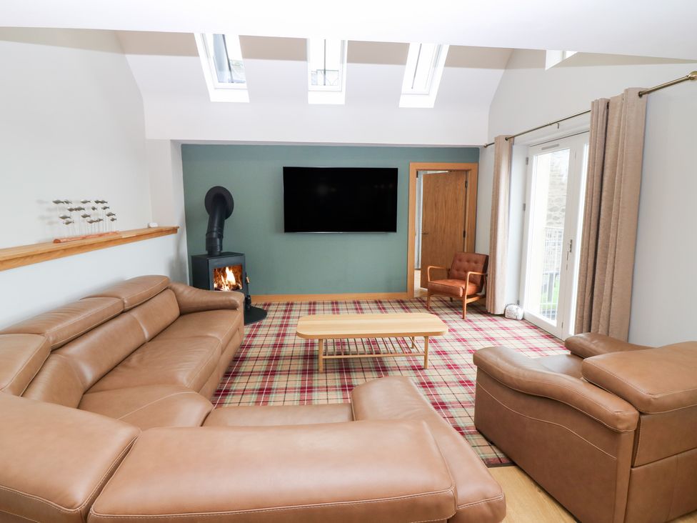 A living room with a sofa and fireplace at The Old Kipper Hoose in Banff