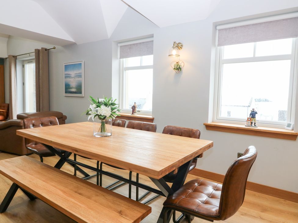 A dining room with a wooden table and chairs at The Old Kipper Hoose in Banff