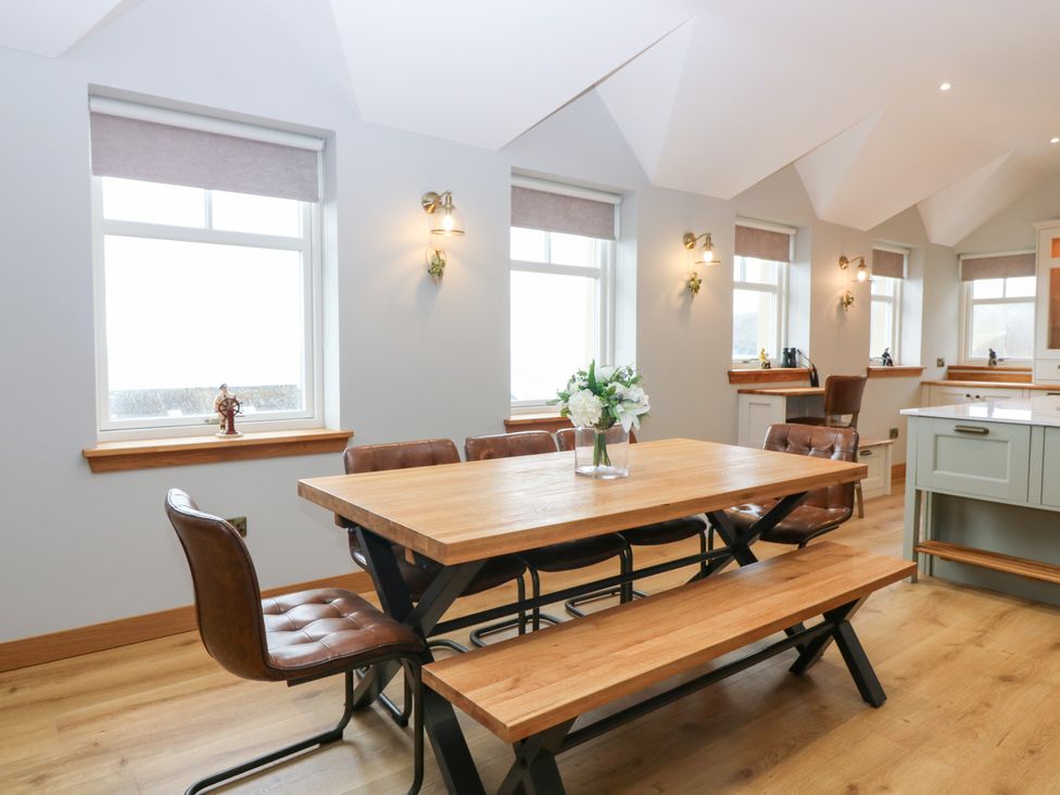 A dining room with a wooden table and chairs at The Old Kipper Hoose in Banff