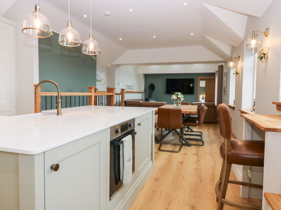 A kitchen with an island and dining area at The Old Kipper Hoose in Banff
