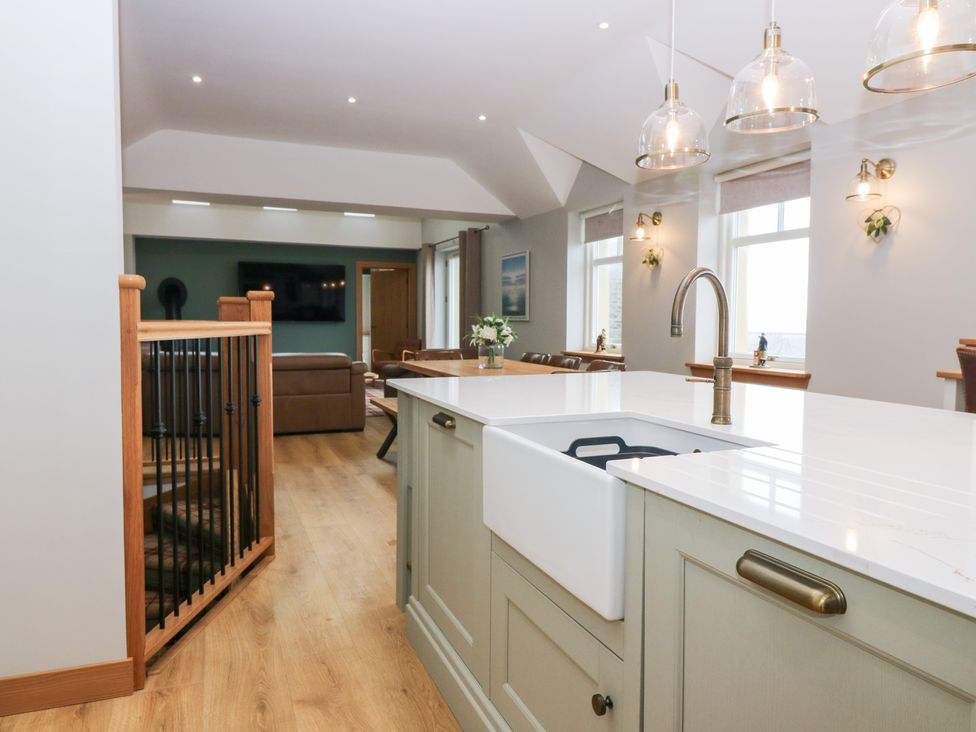 A kitchen with a sink and seating area at The Old Kipper Hoose in Banff