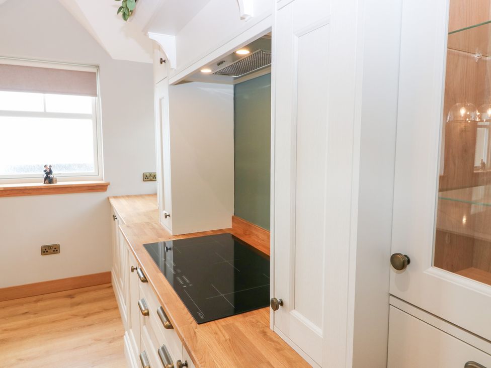 A kitchen with an induction cooktop and cabinets at The Old Kipper Hoose in Banff