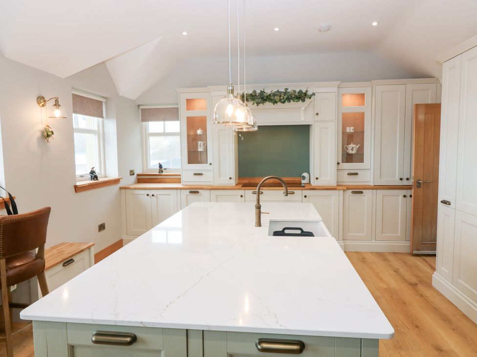 A kitchen with an island and cabinets at The Old Kipper Hoose in Banff