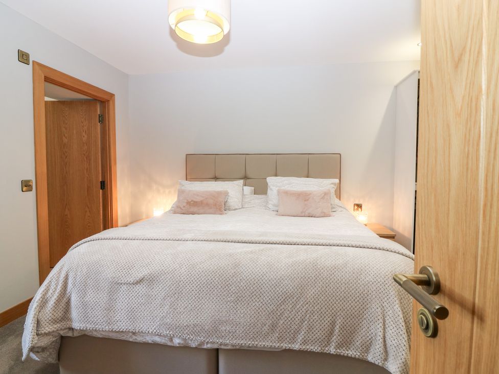 A bedroom with a bed and bedside tables at The Old Kipper Hoose in Banff
