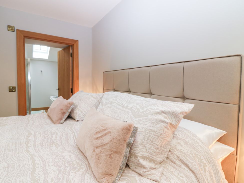 A bedroom with a bed and cushions at The Old Kipper Hoose in Banff