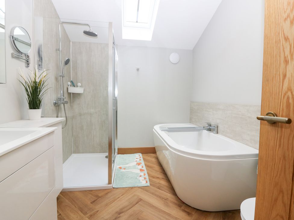 A bathroom with a shower and a bathtub at The Old Kipper Hoose in Banff