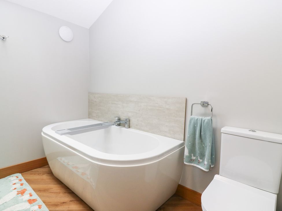 A bathroom with a bath tub and toilet at The Old Kipper Hoose in Banff