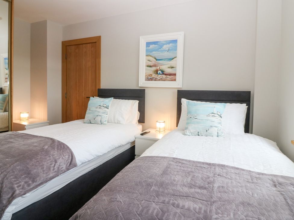 A bedroom with two single beds and a painting at The Old Kipper Hoose Banff