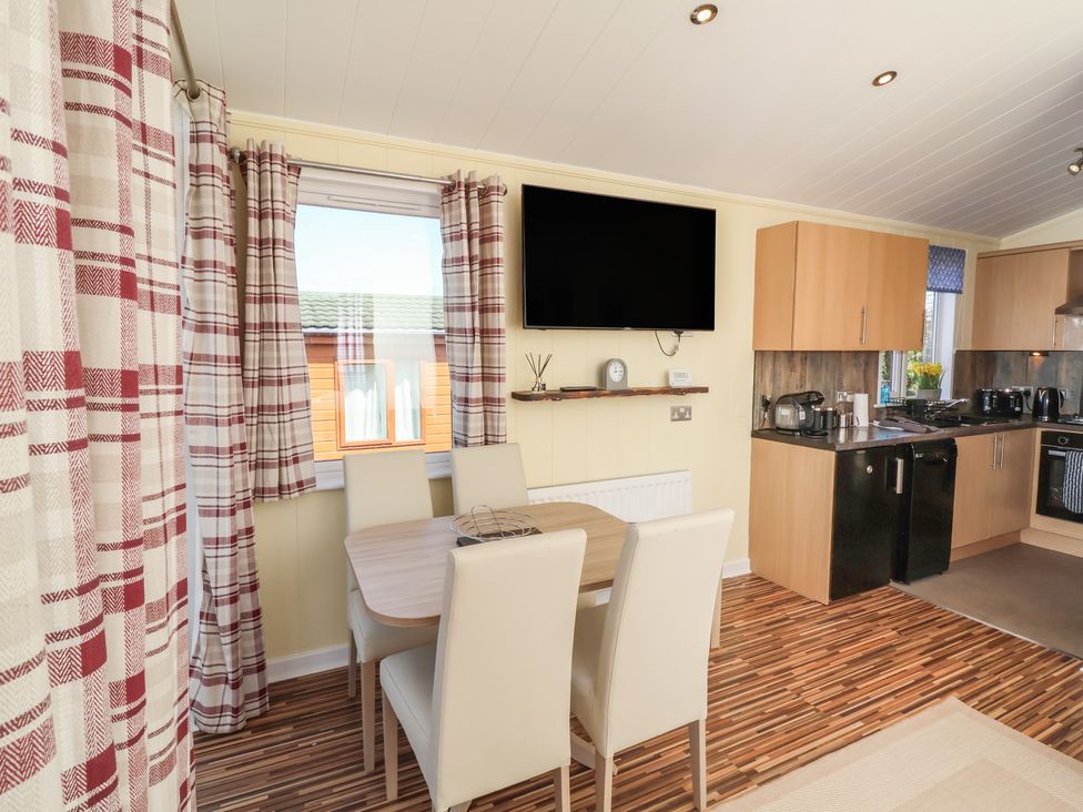 A kitchen with dining table and chairs at Cody Cottage Lodge Mullacott Park near Ilfracombe