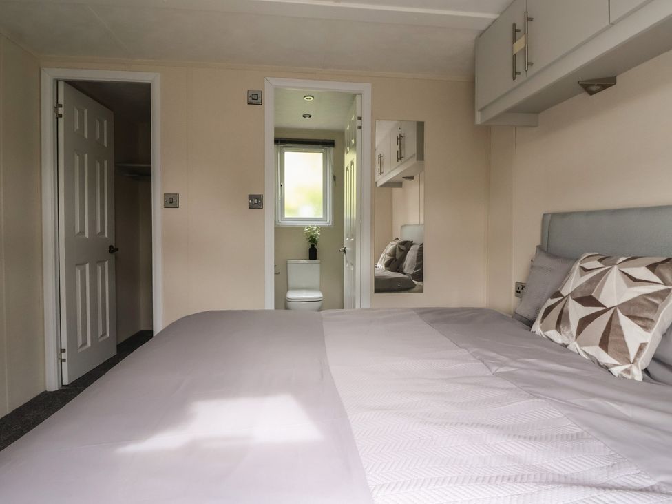 A bedroom with a bed and attached bathroom at Meadows Park 1 in Great Hatfield near Hornsea