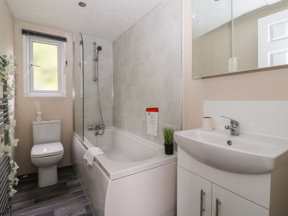 A bathroom with a bathtub and sink at Meadows Park 1 in Great Hatfield near Hornsea