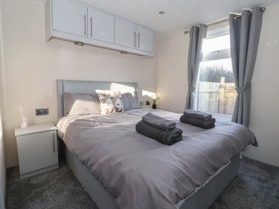 A bedroom with a bed and nightstand at Meadows Park 1 Great Hatfield near Hornsea