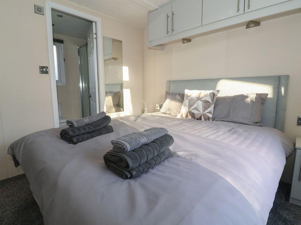 A bedroom with a large bed and towels on top at Meadows Park 1 Great Hatfield near Hornsea
