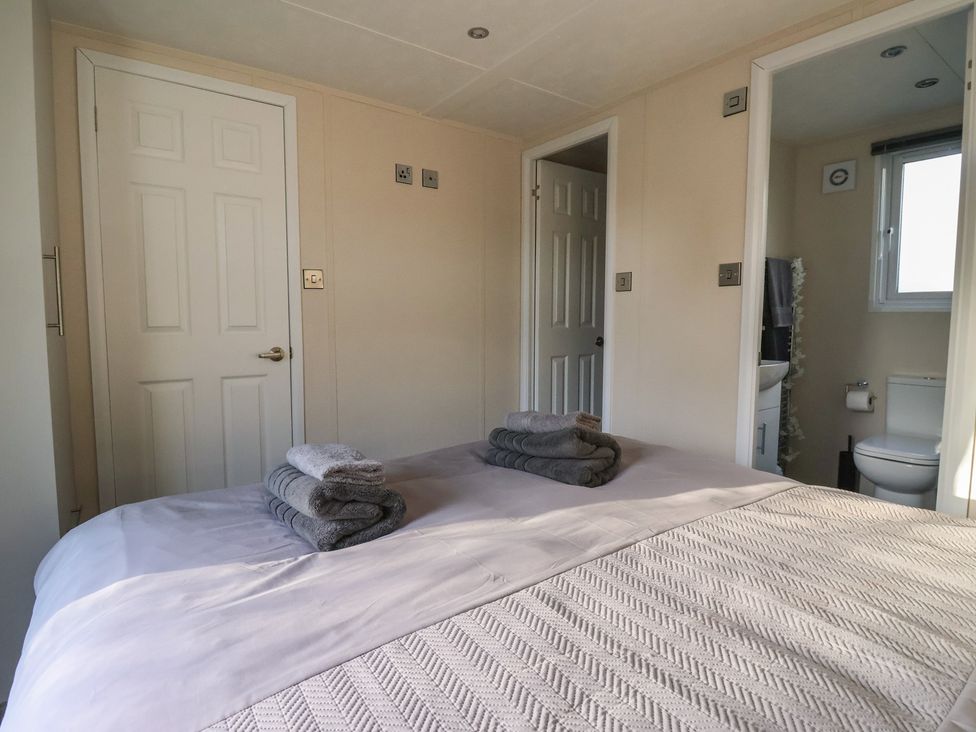 A bedroom with a bed and towels at Meadows Park 1 Great Hatfield near Hornsea