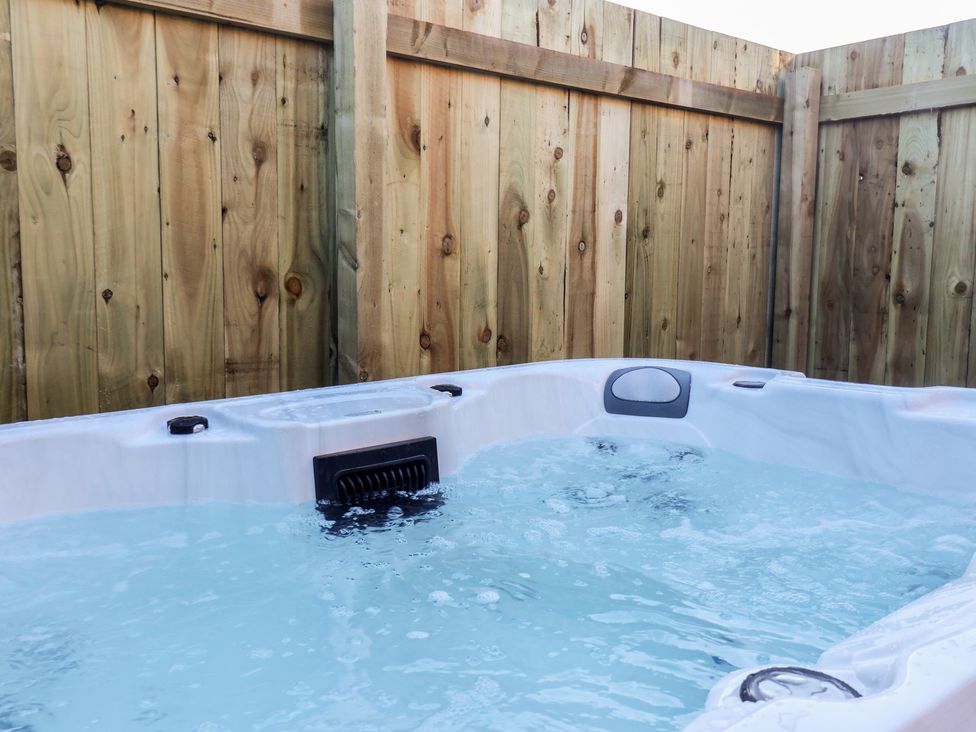 A hot tub surrounded by a wooden fence at Meadows Park 1 Great Hatfield near Hornsea
