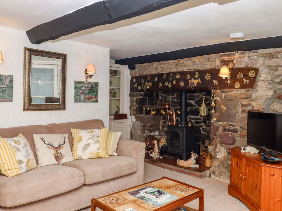 A living room with a fireplace and a sofa at Cosy Nook in South Molton