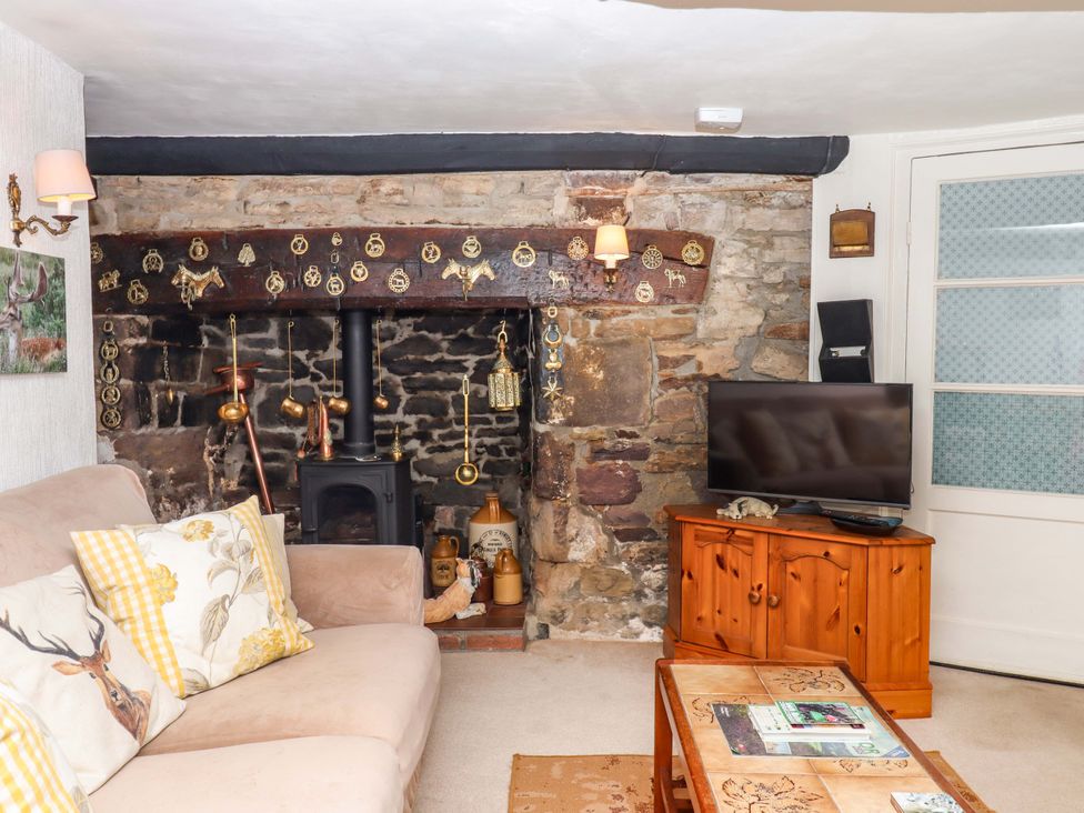 A living room with a fireplace and sofa at Cosy Nook in South Molton