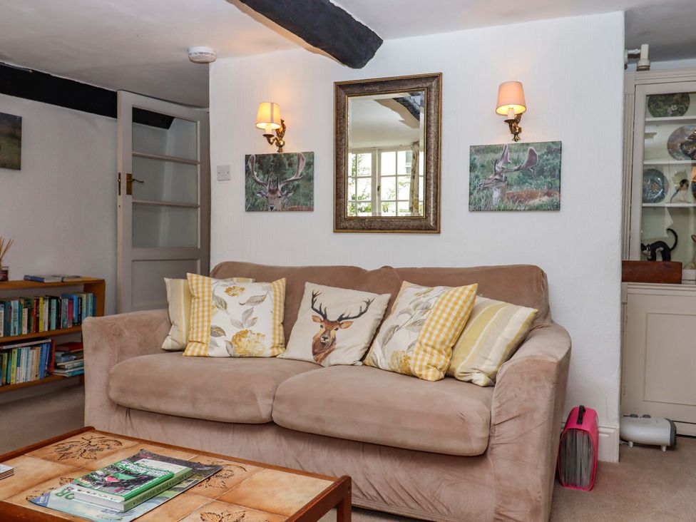 A living room with a sofa and bookshelf at Cosy Nook in South Molton
