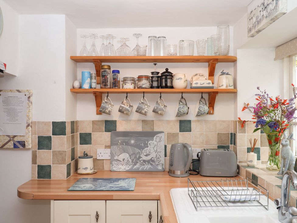 A kitchen with shelves and kitchen appliances at Cosy Nook in South Molton