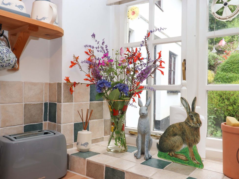 A kitchen with a vase of flowers and a toaster at Cosy Nook in South Molton