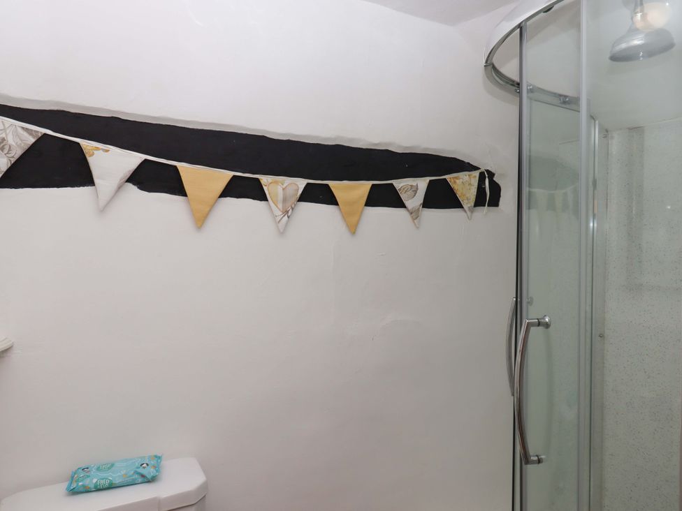 A bathroom with a shower and bunting at Cosy Nook in South Molton