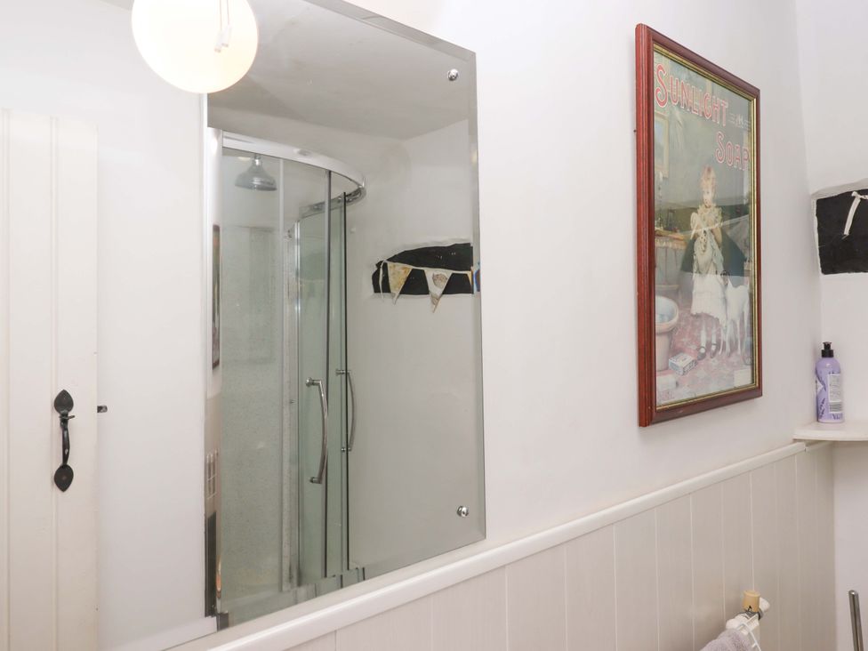 A bathroom with a shower and mirror at Cosy Nook South Molton