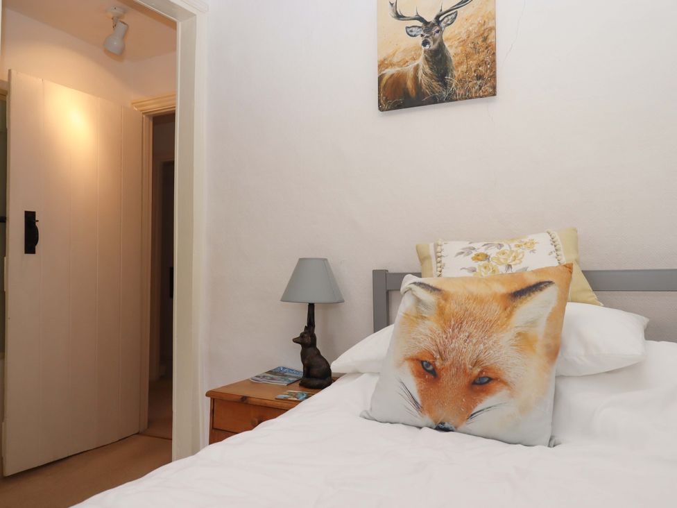 A bedroom with a fox pillow and a deer painting at Cosy Nook in South Molton