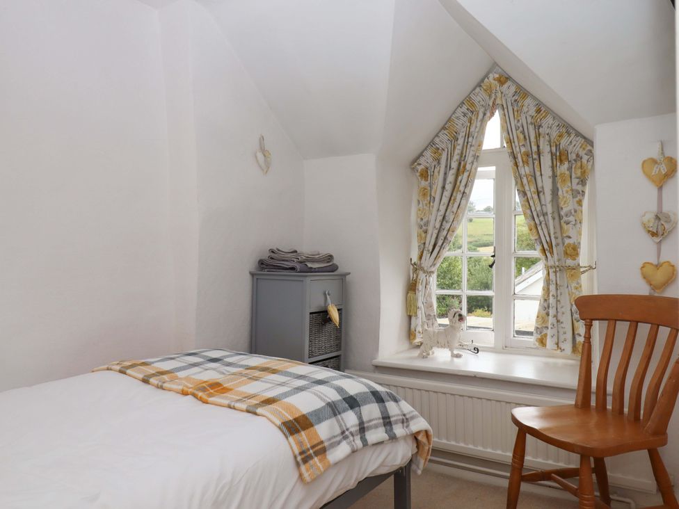 A bedroom with a bed and chair at Cosy Nook in South Molton