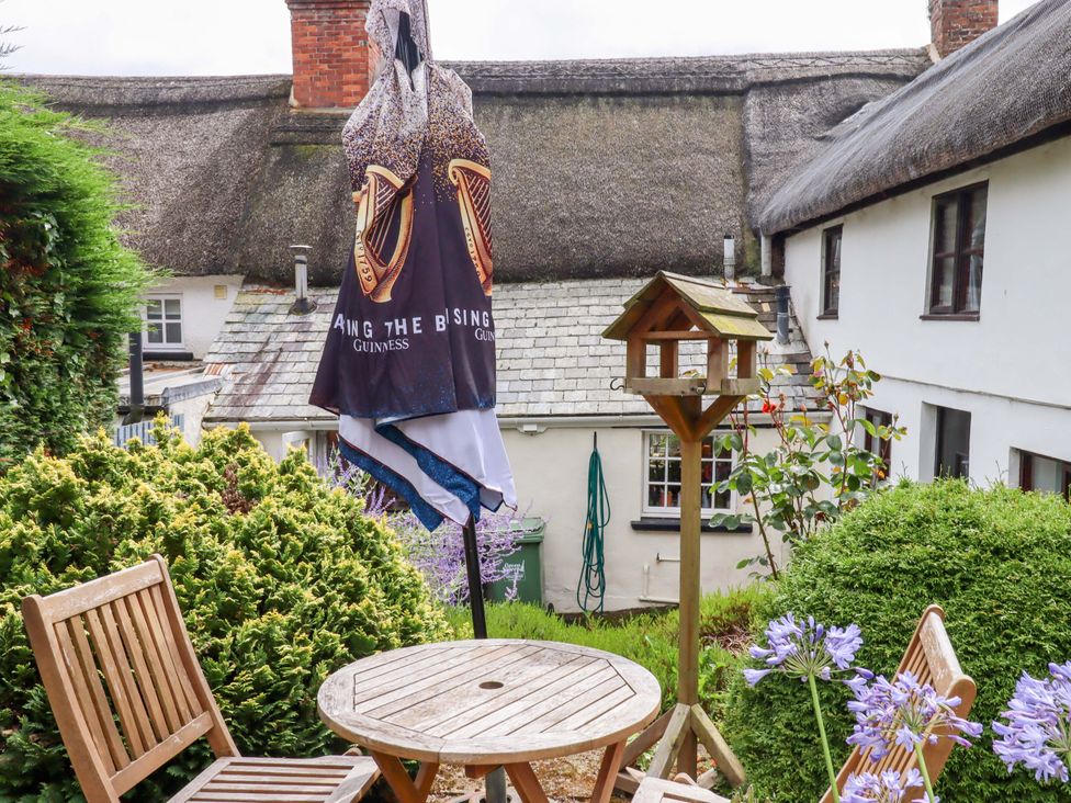 A garden with a table, chairs, and an umbrella at Cosy Nook in South Molton