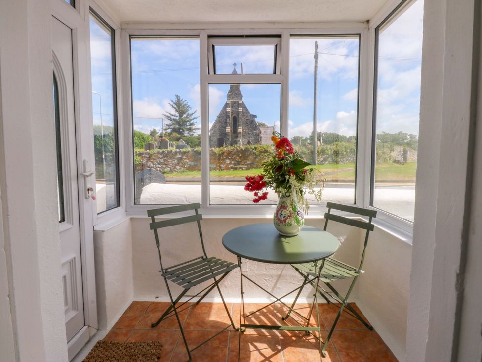 A conservatory with a table and chairs at Cae Gwyn in Ty Croes