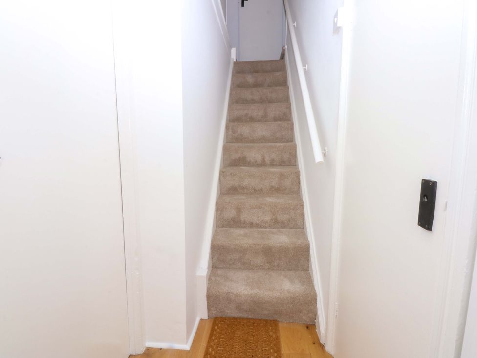 A hallway with stairs and a door at Cae Gwyn in Ty Croes