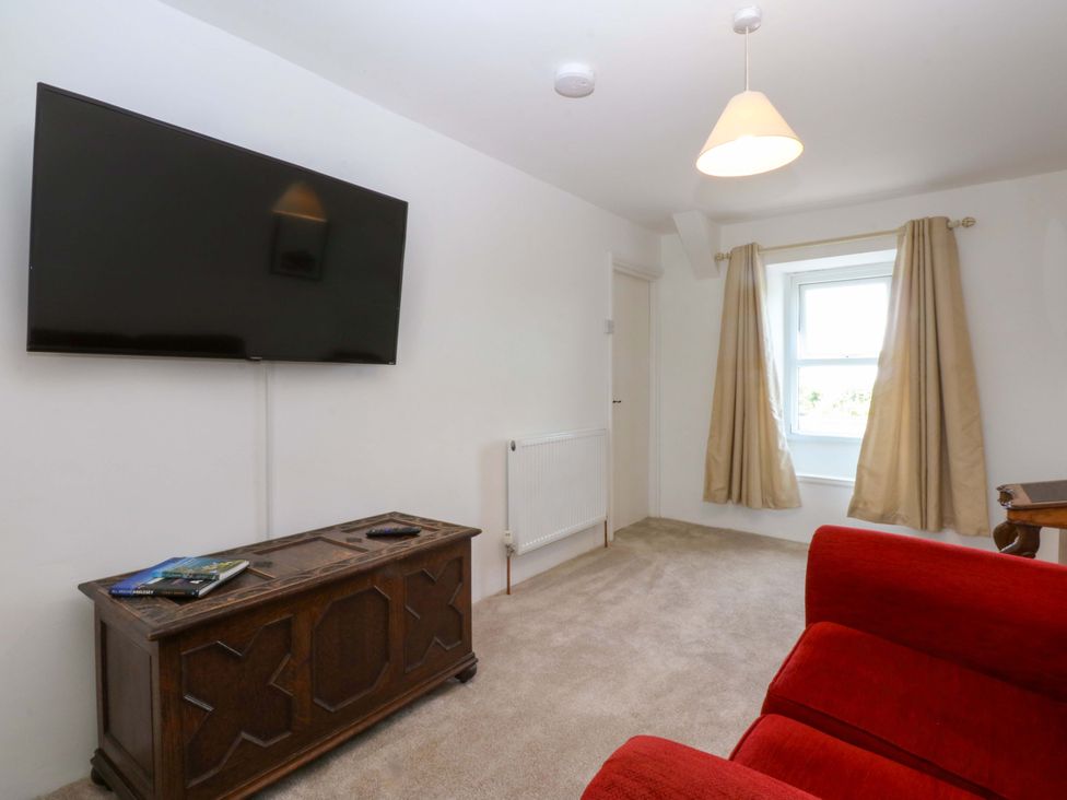 A living room with a television and a storage chest at Cae Gwyn in Ty Croes