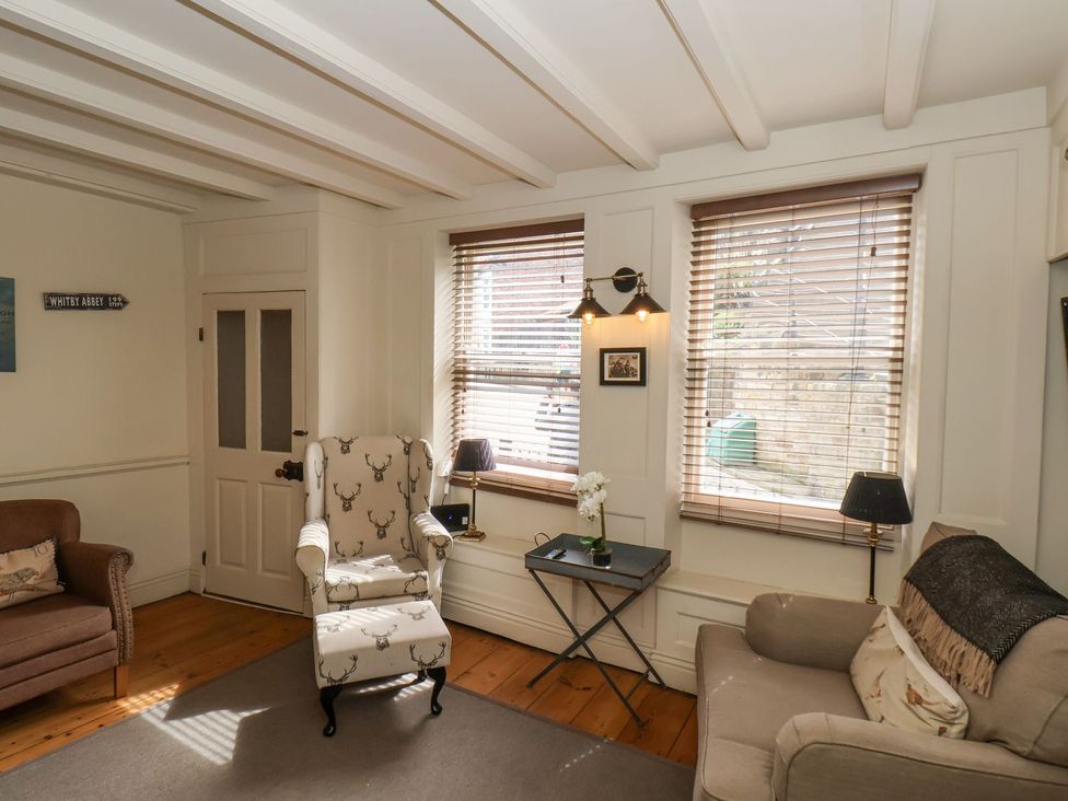 A living room with armchair and table at Greenfingers in Whitby